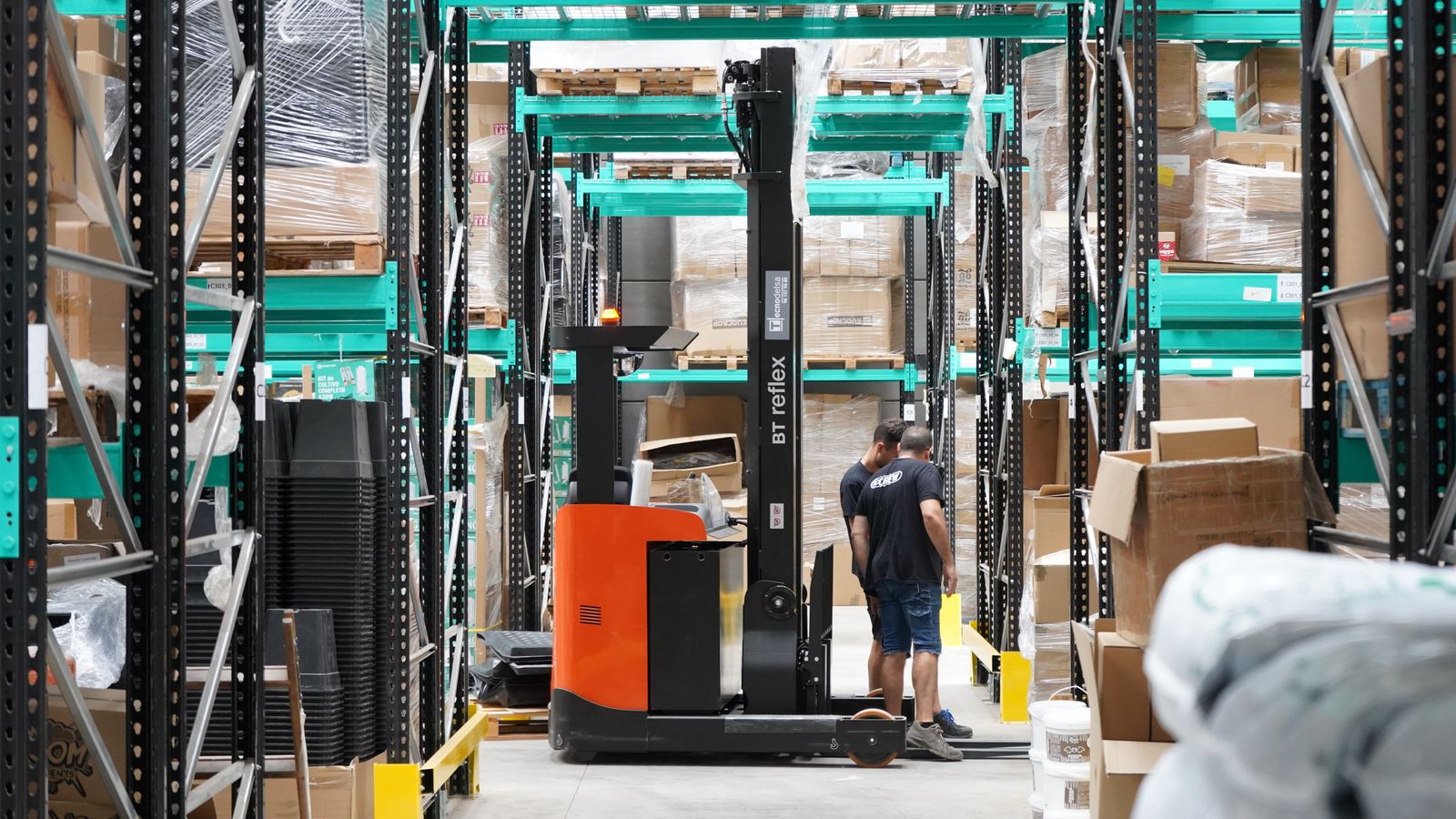 Workers and forklift in a modern warehouse environment